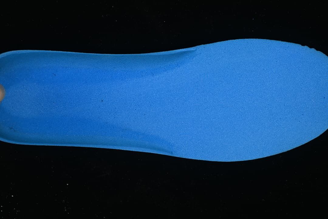 Blue shoe insole shown against a dark background.