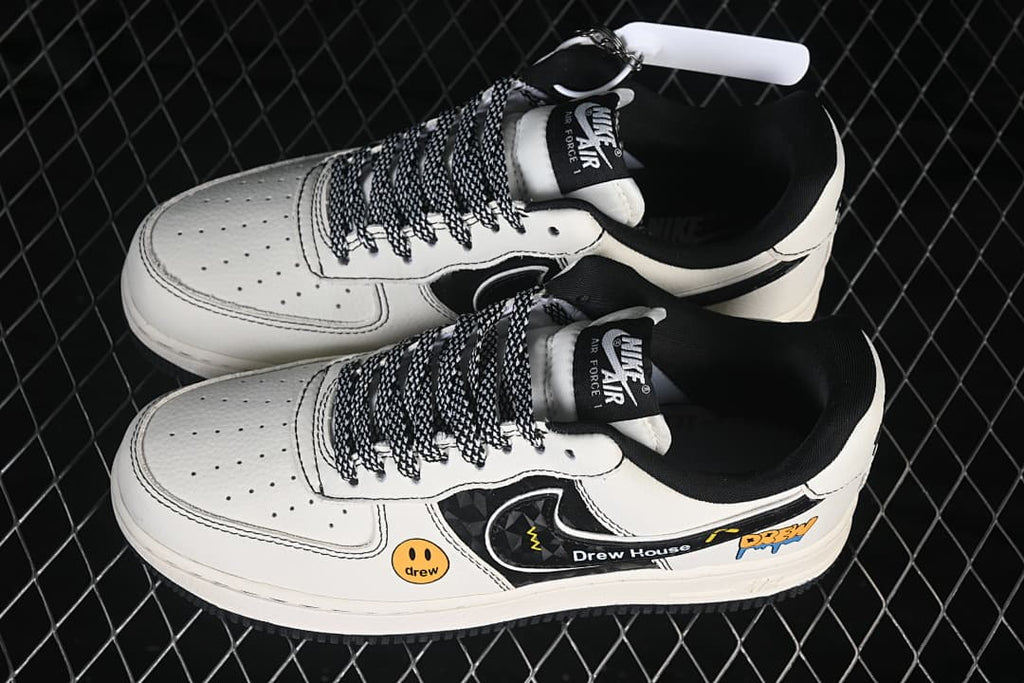 Pair of white and black low-top sneakers with patterned side panels and graphic details