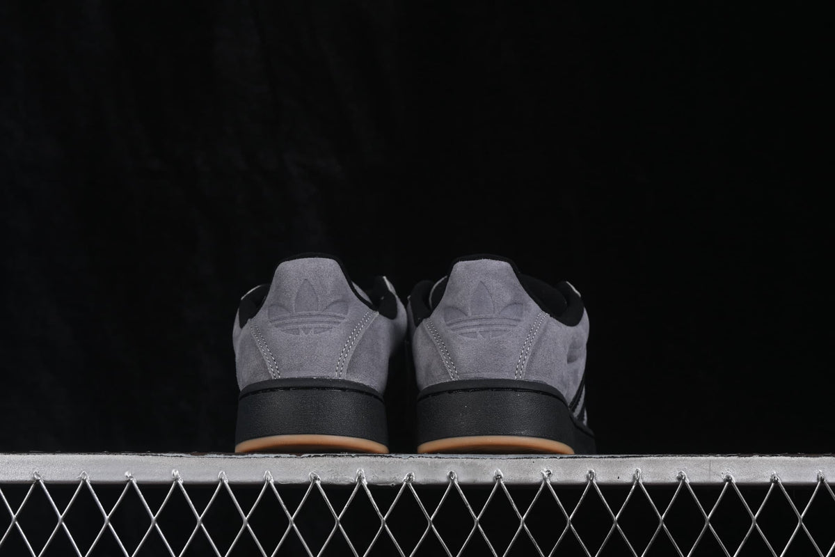 Rear view showing the grey heel panels, Adidas trefoil details, black midsoles, and gum-colored outsole edges.