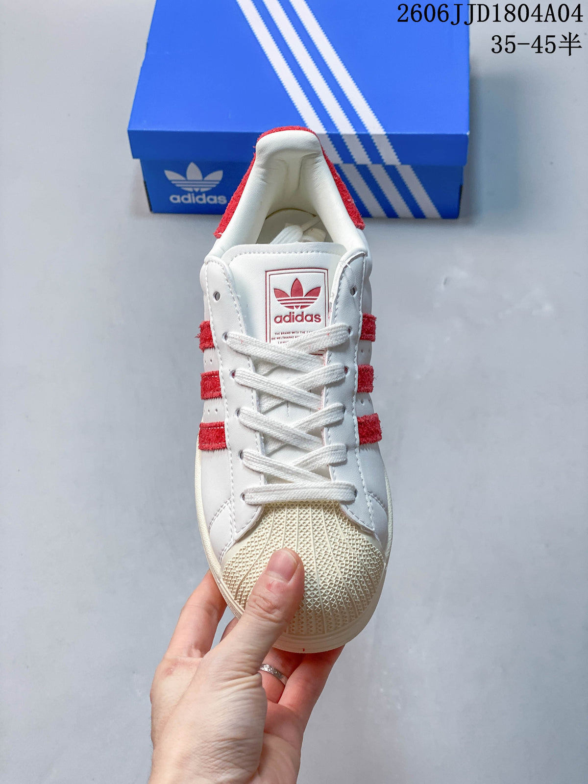 Front view showing the textured shell toe, white laces, and red side stripes.