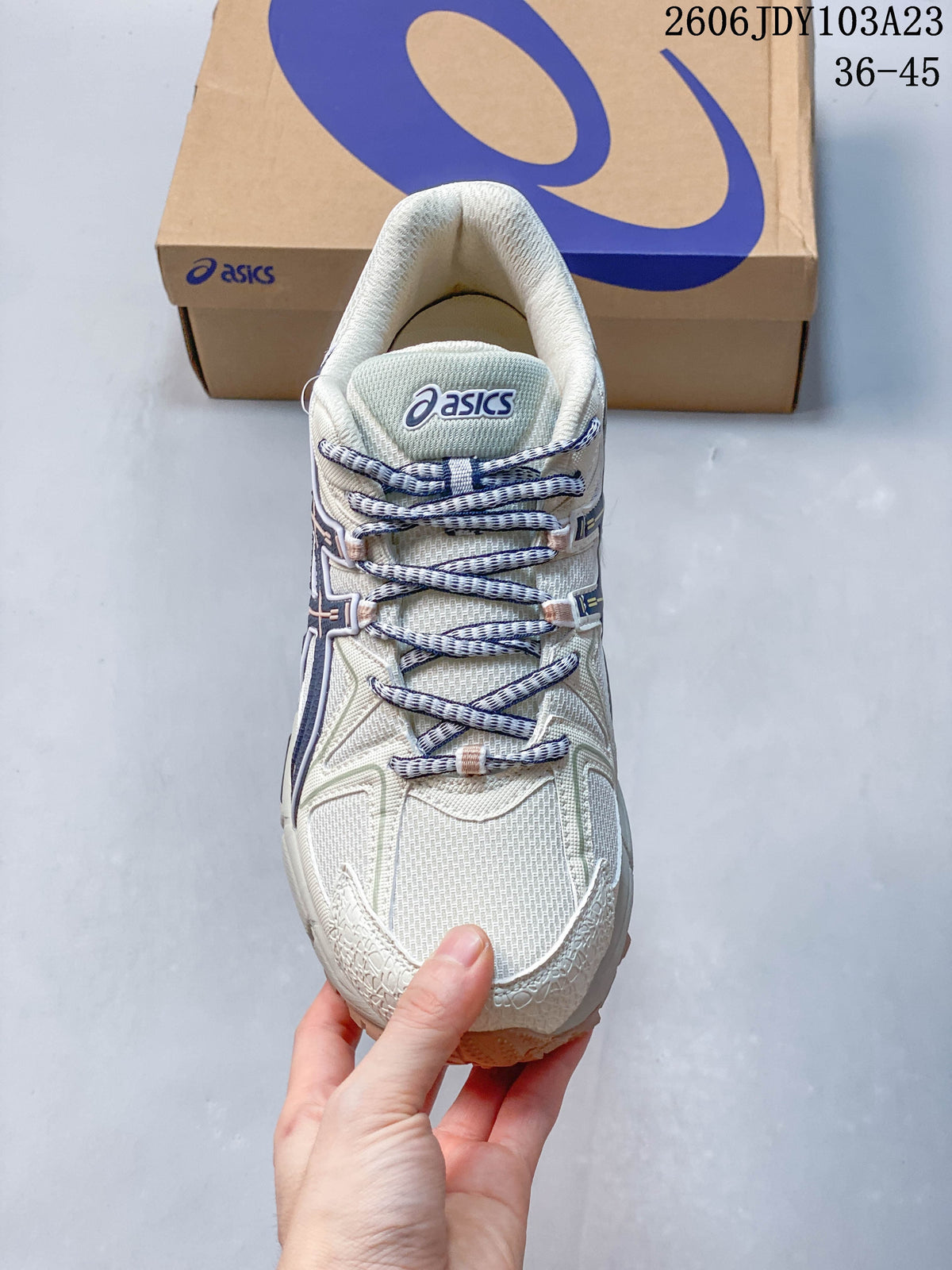 Top view of the cream sneaker, patterned laces, and tongue logo