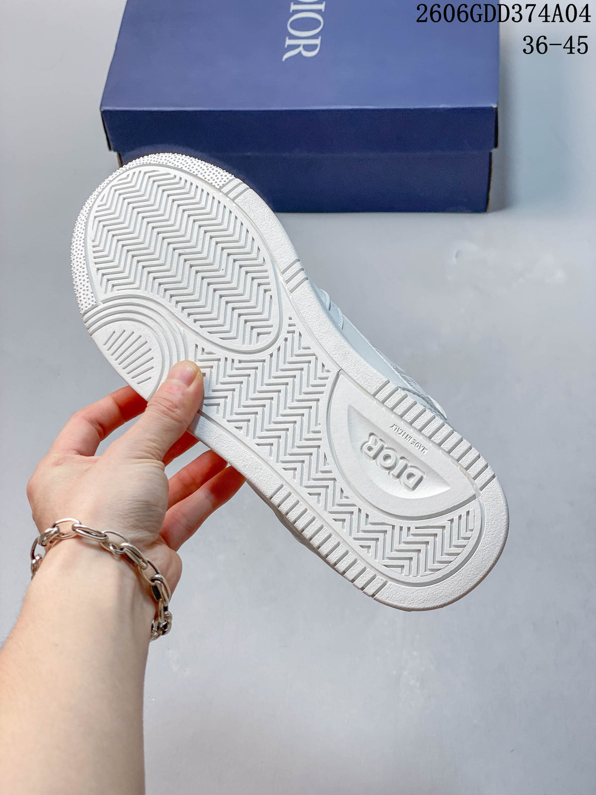 Underside of a white sneaker showing a textured zigzag outsole and Dior branding.