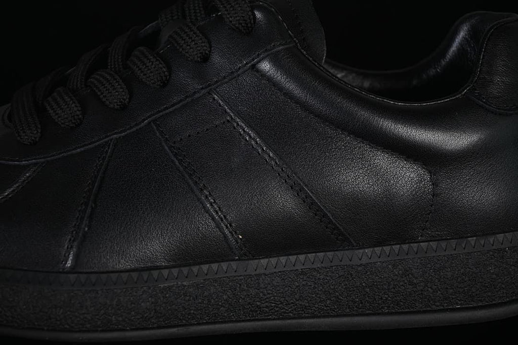 Close-up of stitched side panels, laces, and textured sole