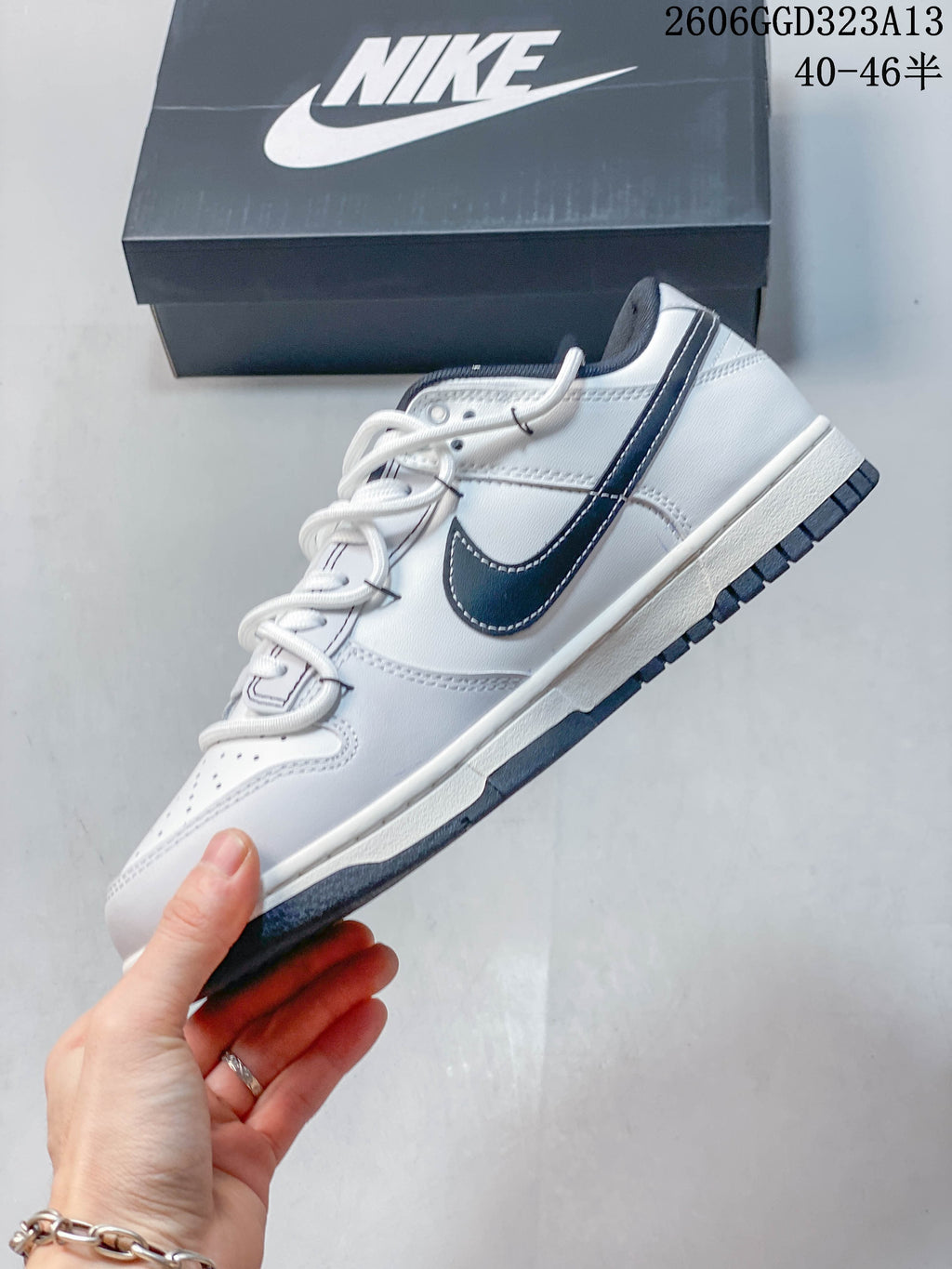 Side profile of a white low-top sneaker with a dark navy Swoosh and outsole