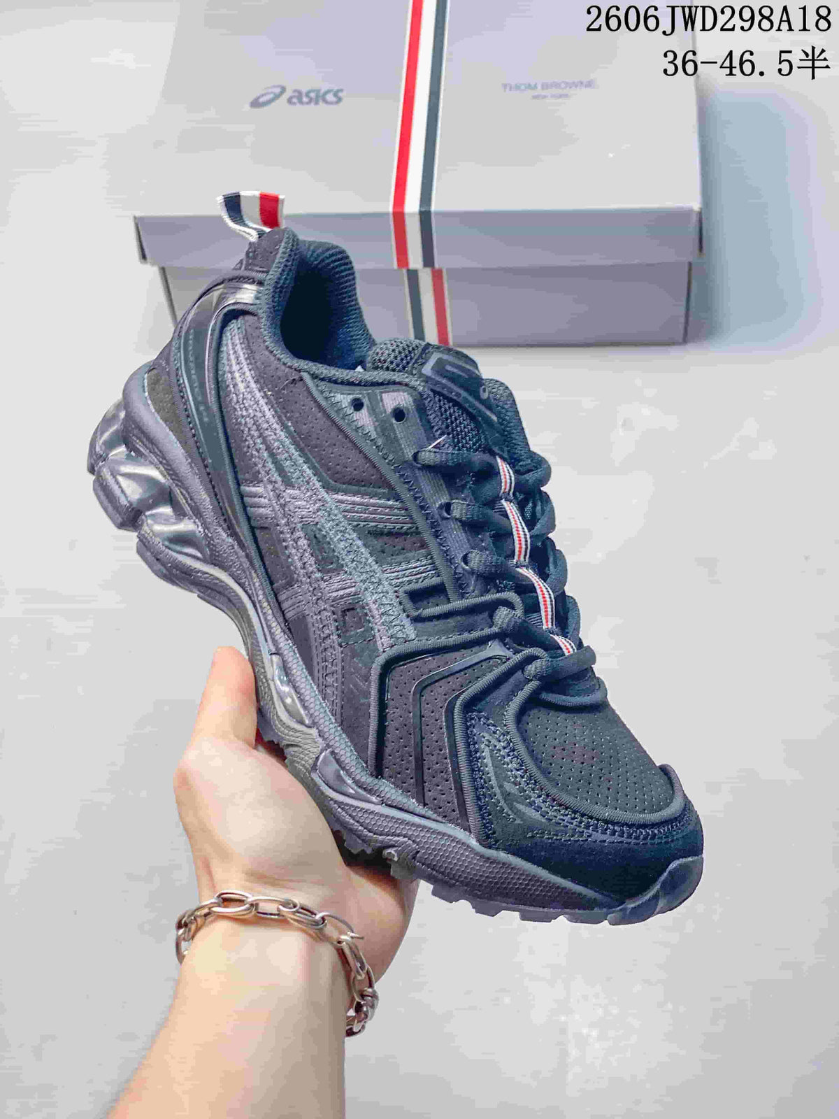 Side view of the dark gray ASICS sneaker with layered panels and sculpted sole