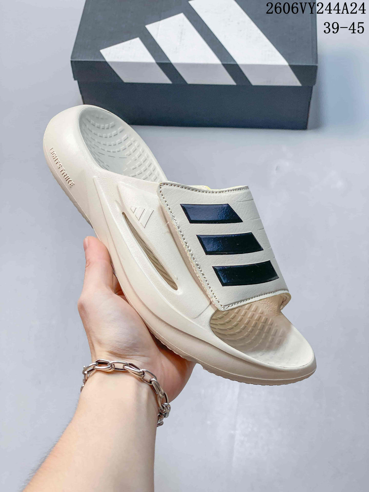 Cream-colored slide with dark three-stripe detailing and textured footbed; image overlay lists sizes 39–45.
