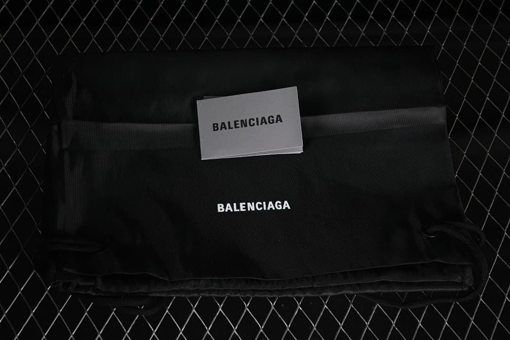 Black branded fabric bag and card pictured with the sneakers
