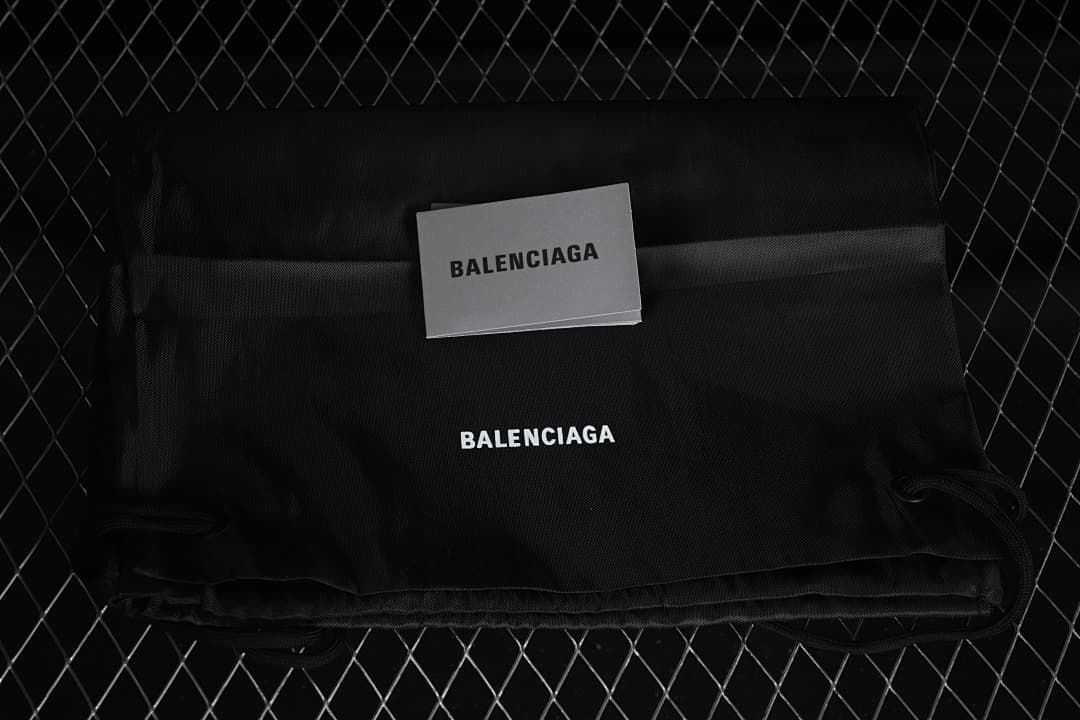 Black branded fabric bag and card pictured with the sneakers