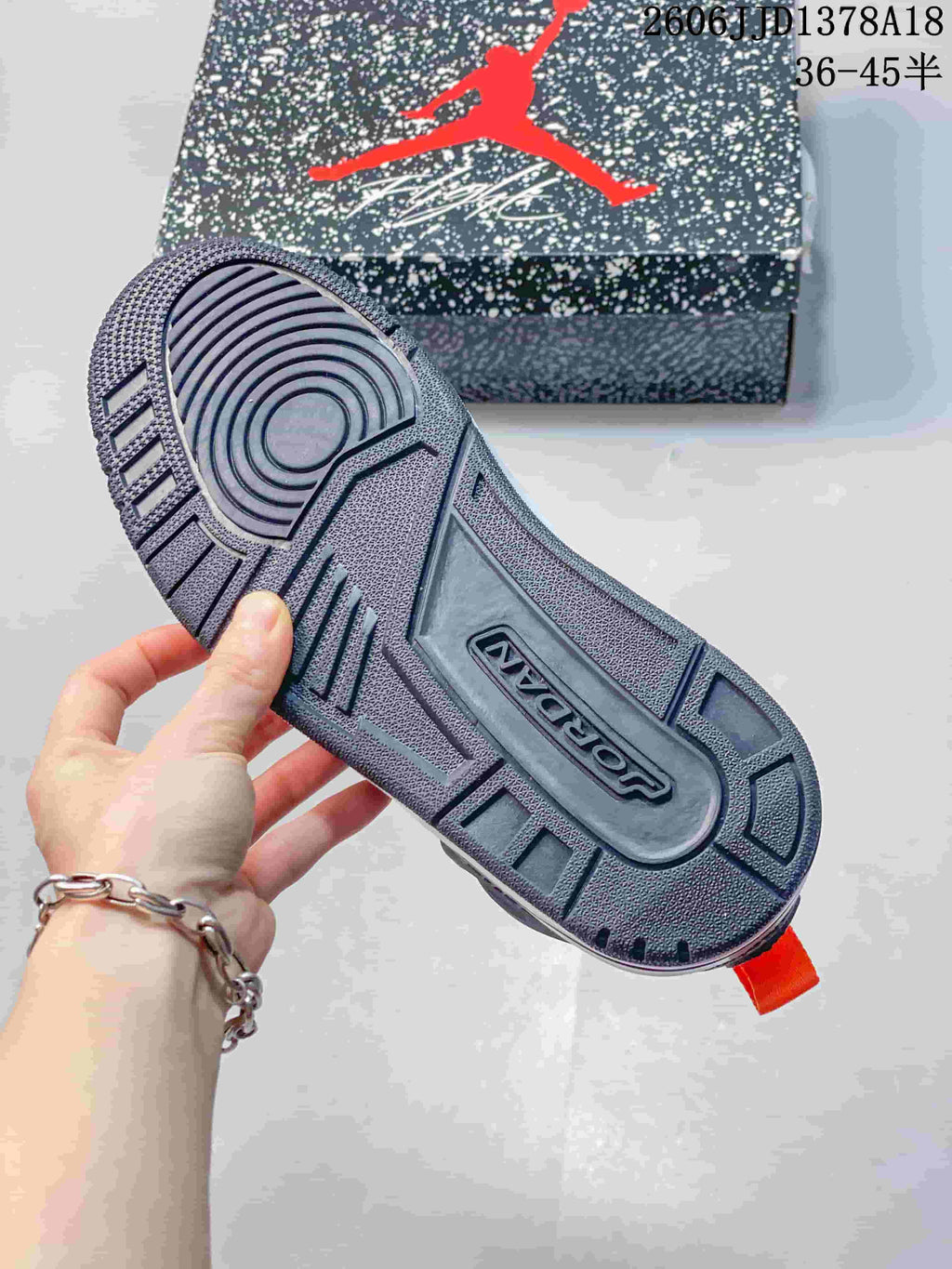 Close-up of the sneaker's patterned outsole and speckled shoebox.