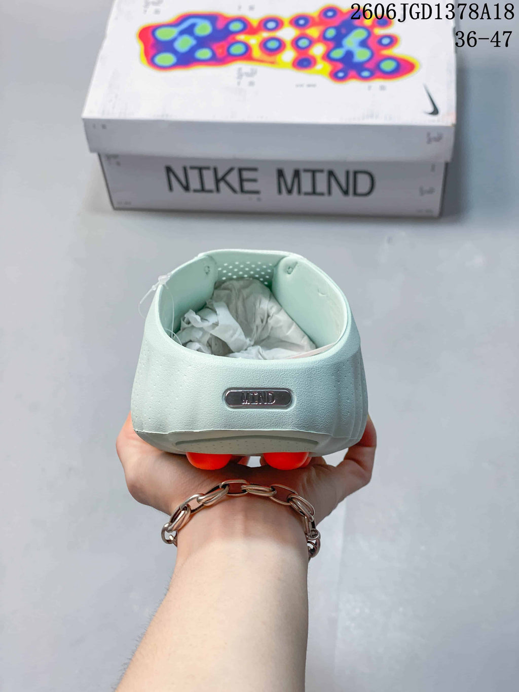 Rear view of a pale mint Nike Mind slide with a Mind badge