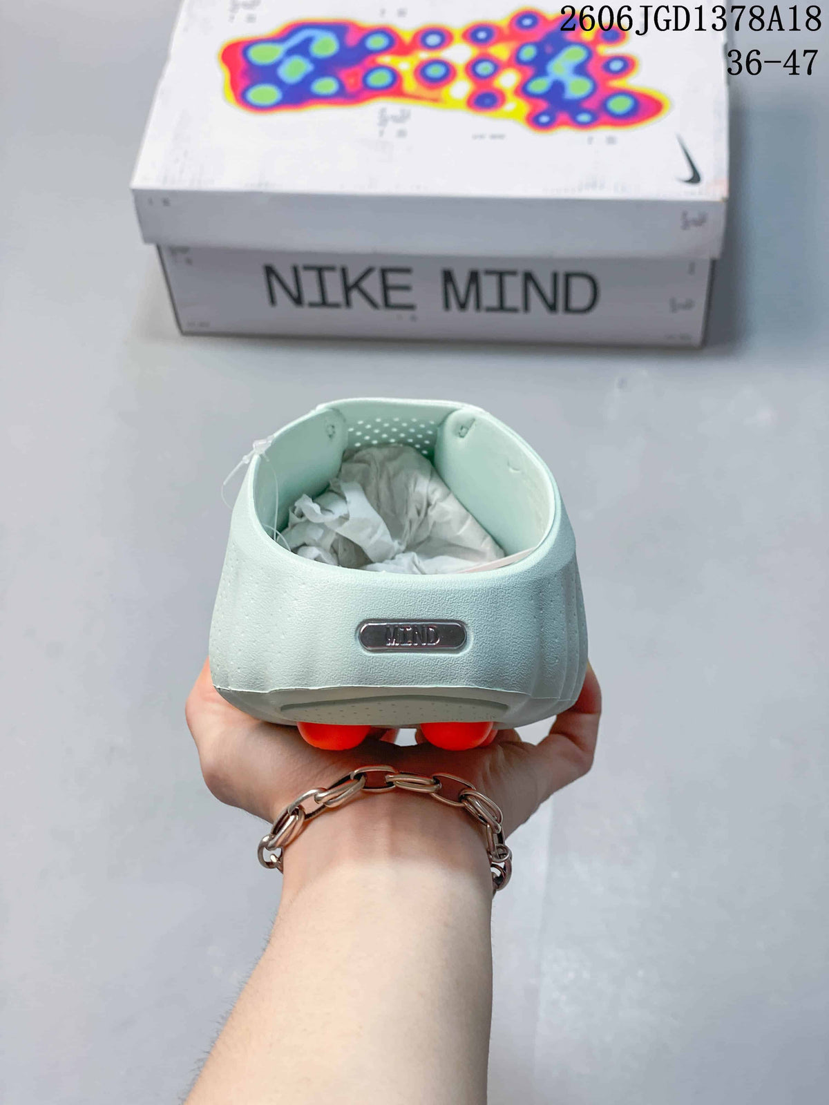Rear view of a pale mint Nike Mind slide with a Mind badge