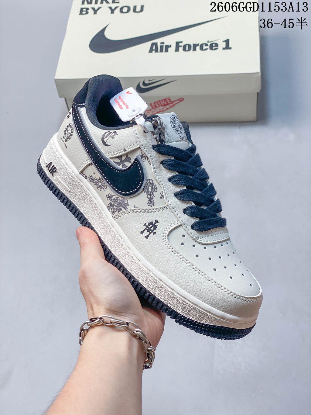 Angled view of the sneaker showing printed side panels, navy Swoosh, and metal charm