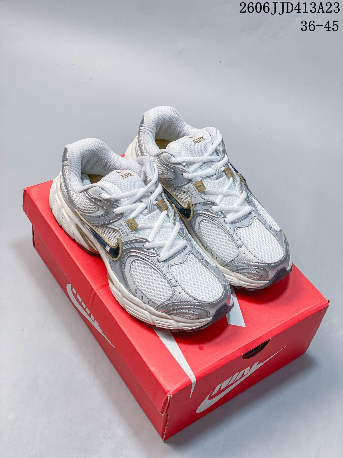 Pair of white and silver Nike Air Zoom Winflo 12 shoes shown on a red shoe box