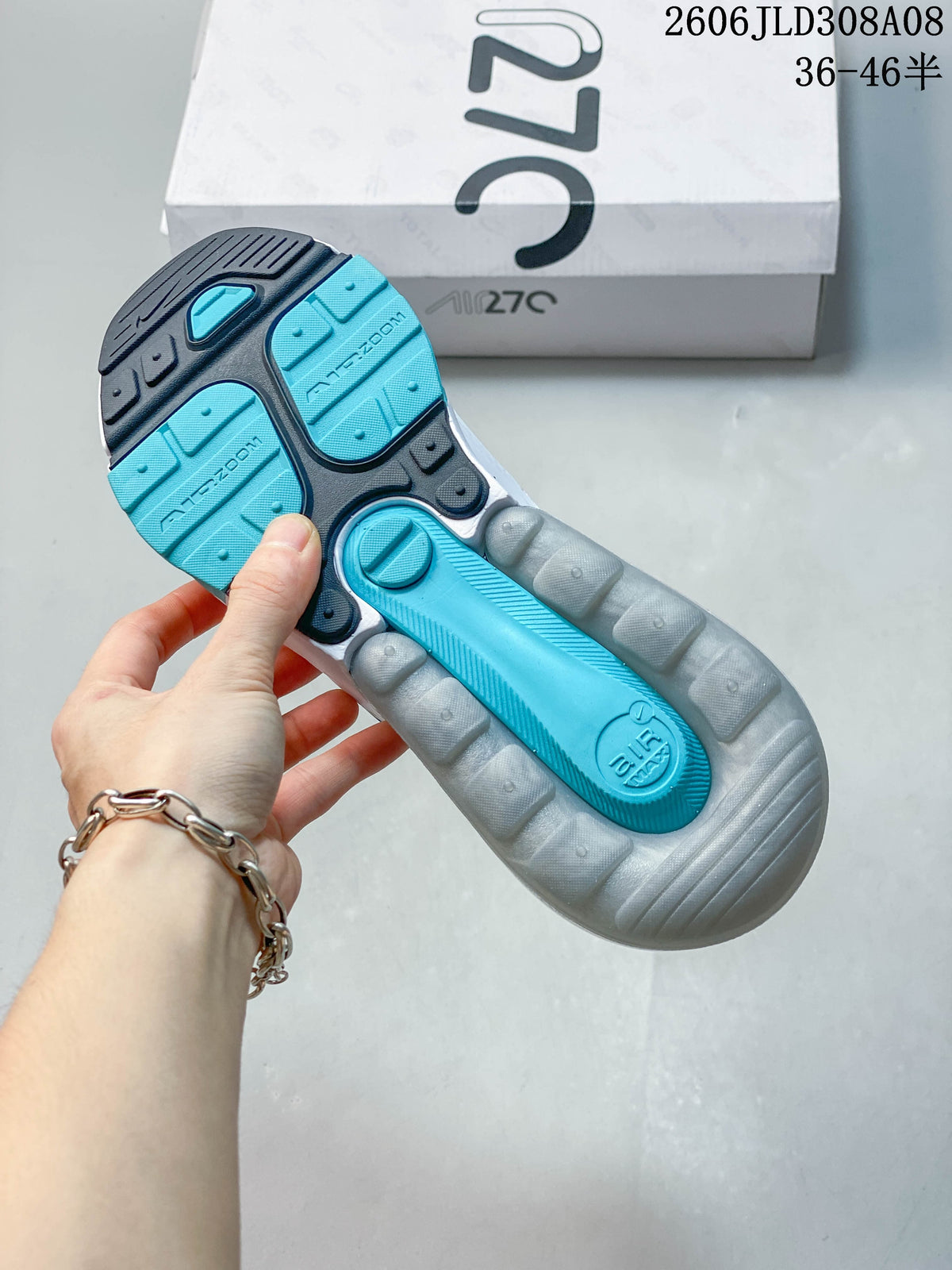 Underside of a Nike Air Max 270 sneaker showing turquoise and dark gray outsole sections