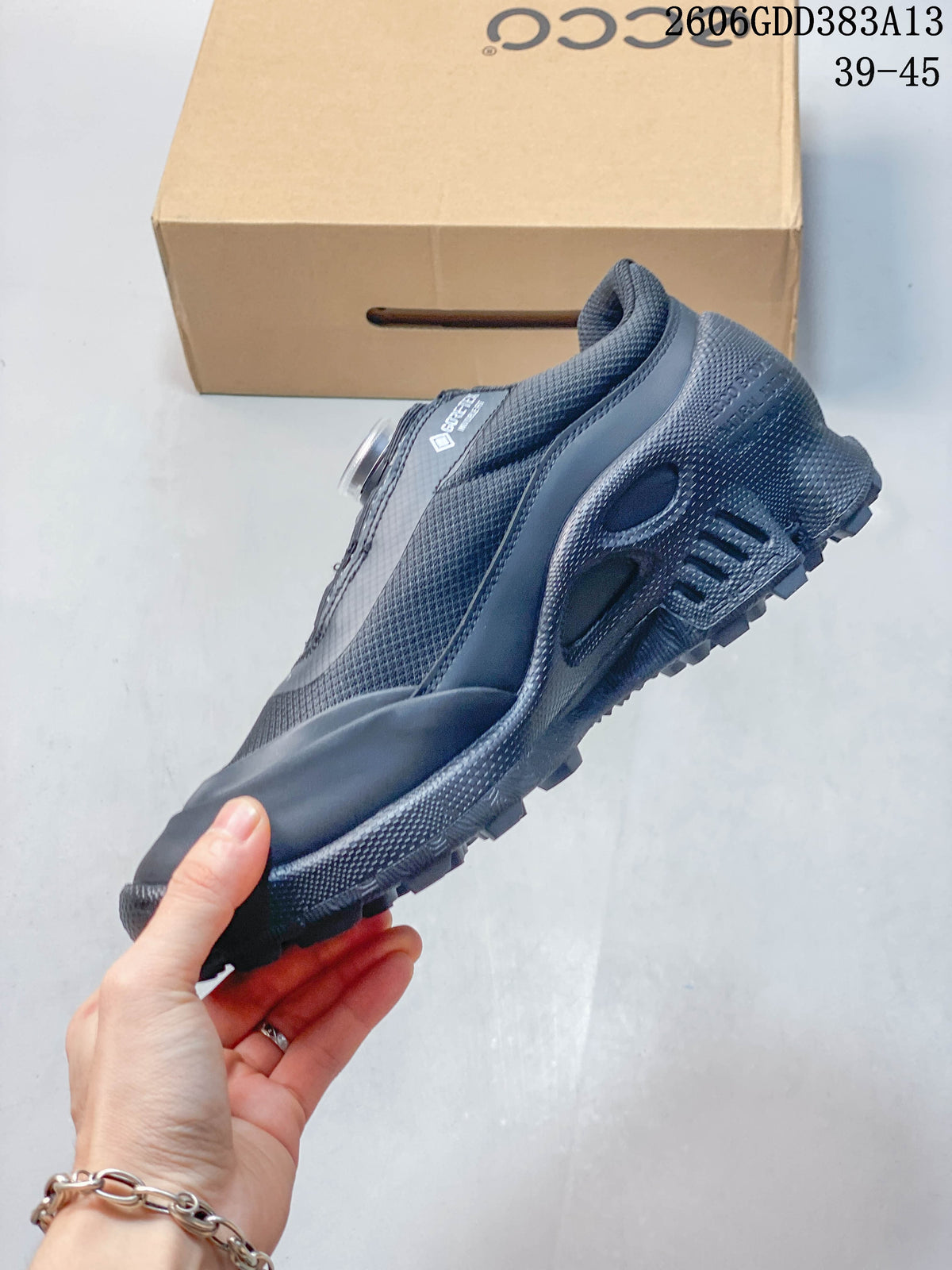 Side view of the gray shoe with dial closure and textured outsole