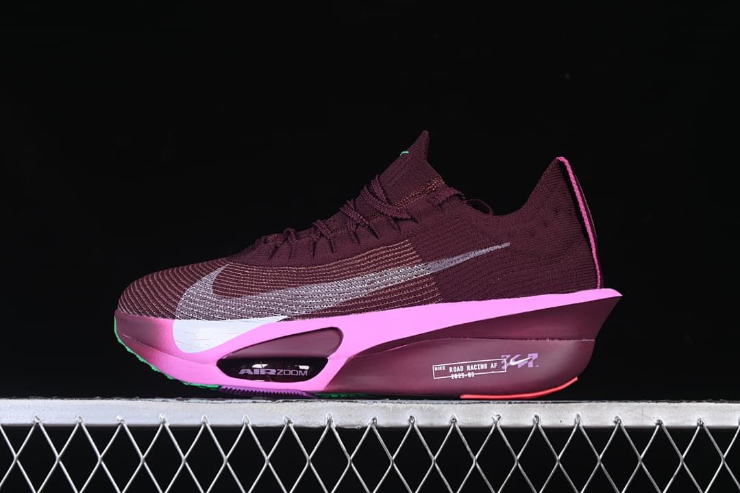 Side view of a burgundy Nike-branded road racing shoe with a bright pink sole accent