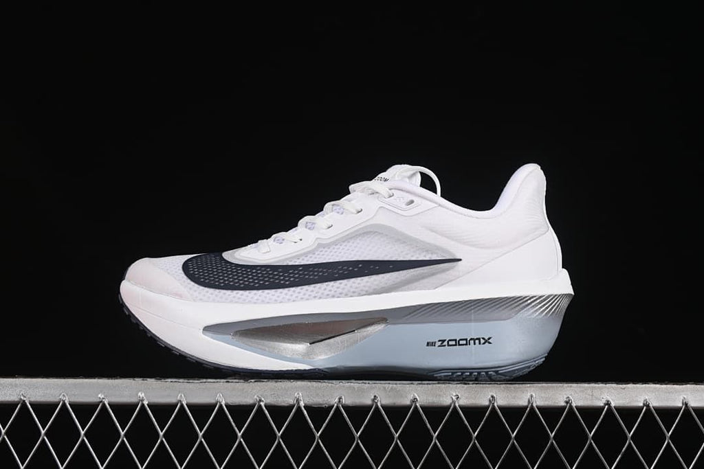 Side view of a white Nike Zoom Fly 6 running shoe with a dark Swoosh and sculpted midsole.