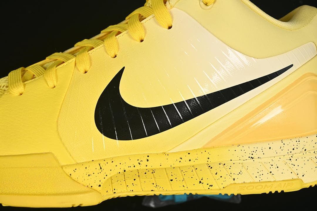 Close-up of the yellow upper, black Swoosh and speckled midsole