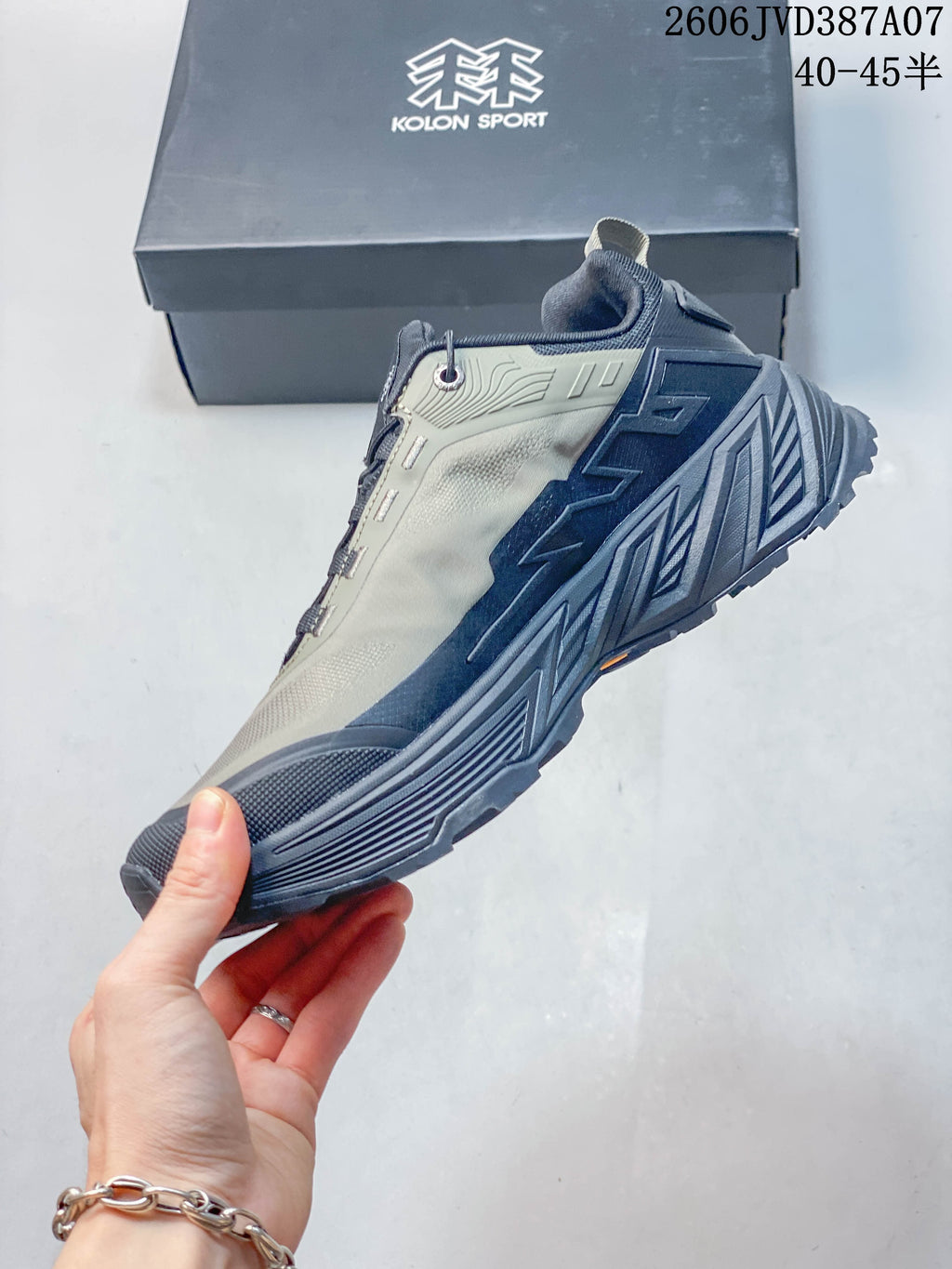 Side view of the gray and navy low-top sneaker