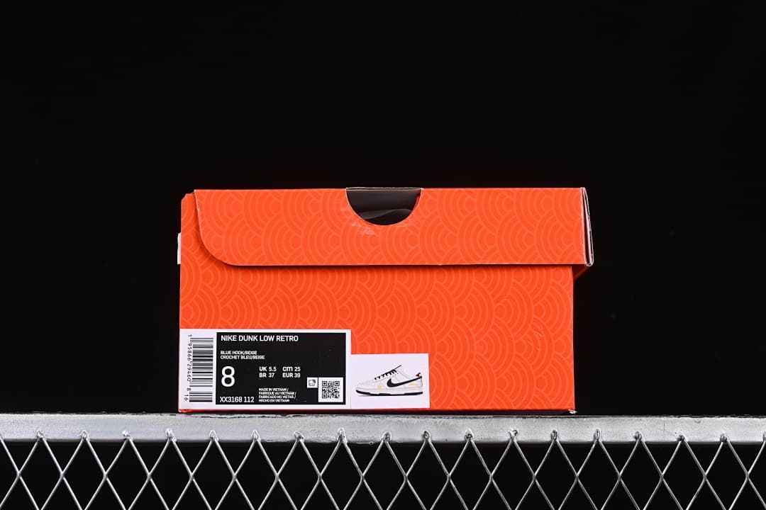 Orange patterned shoe box with a label showing Nike Dunk Low Retro and sample size details