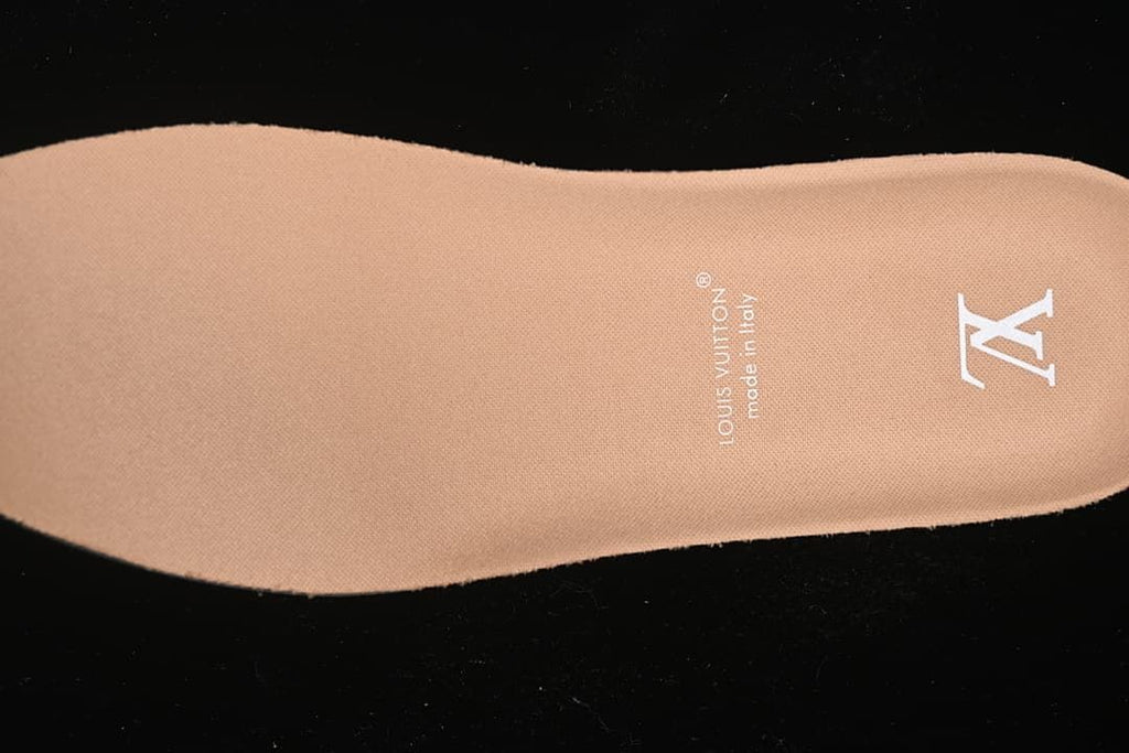 Close view of a tan insole with visible printed branding.