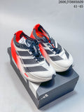Pair of white adidas Adizero Dropset Elite shoes with dark detailing and bright red heels, displayed on a box