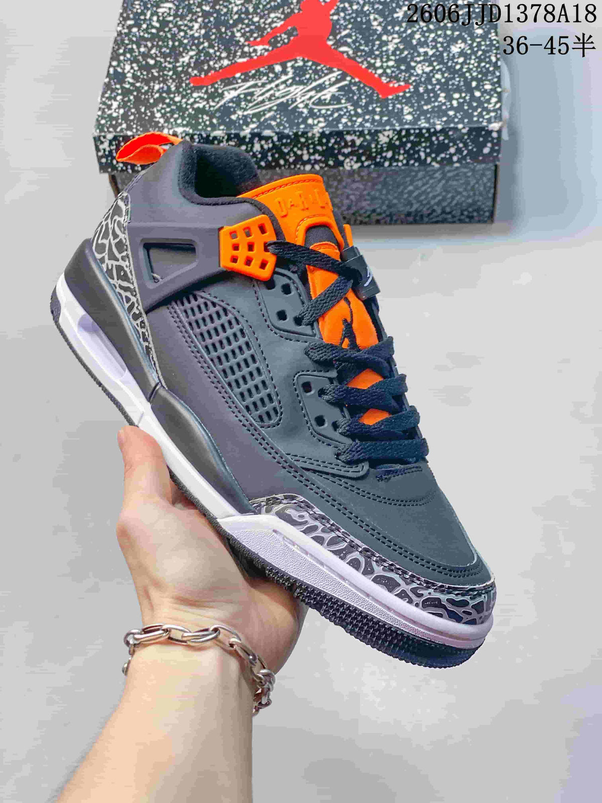 Angled side view of the Jordan Spizike low-top sneaker with orange accents and patterned overlays.