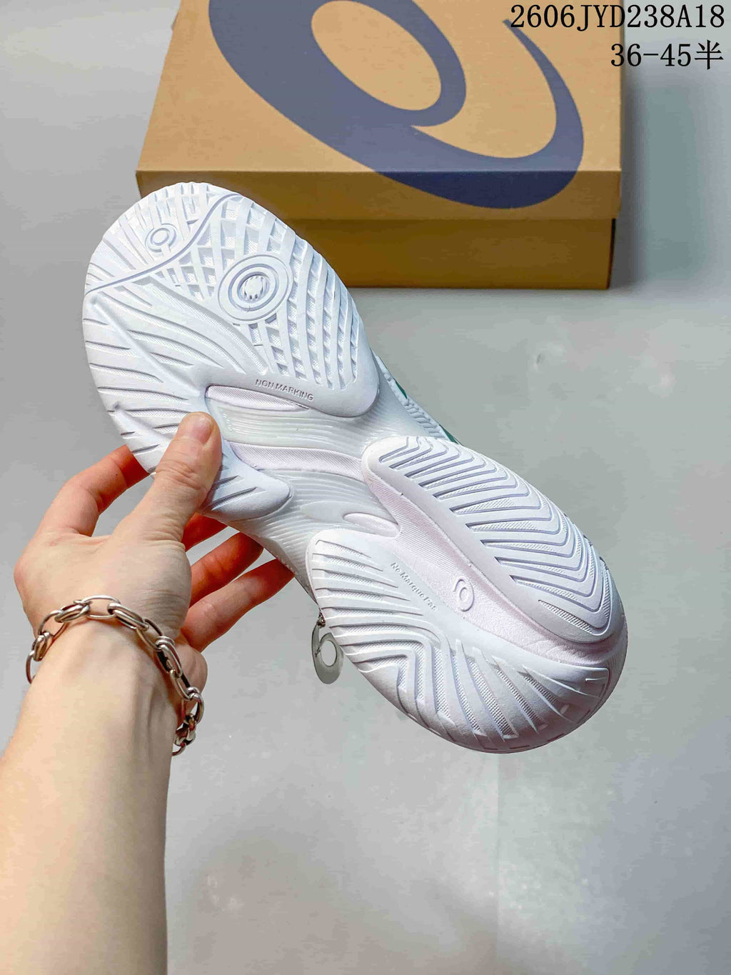 Close-up of the textured outsole on a white tennis shoe
