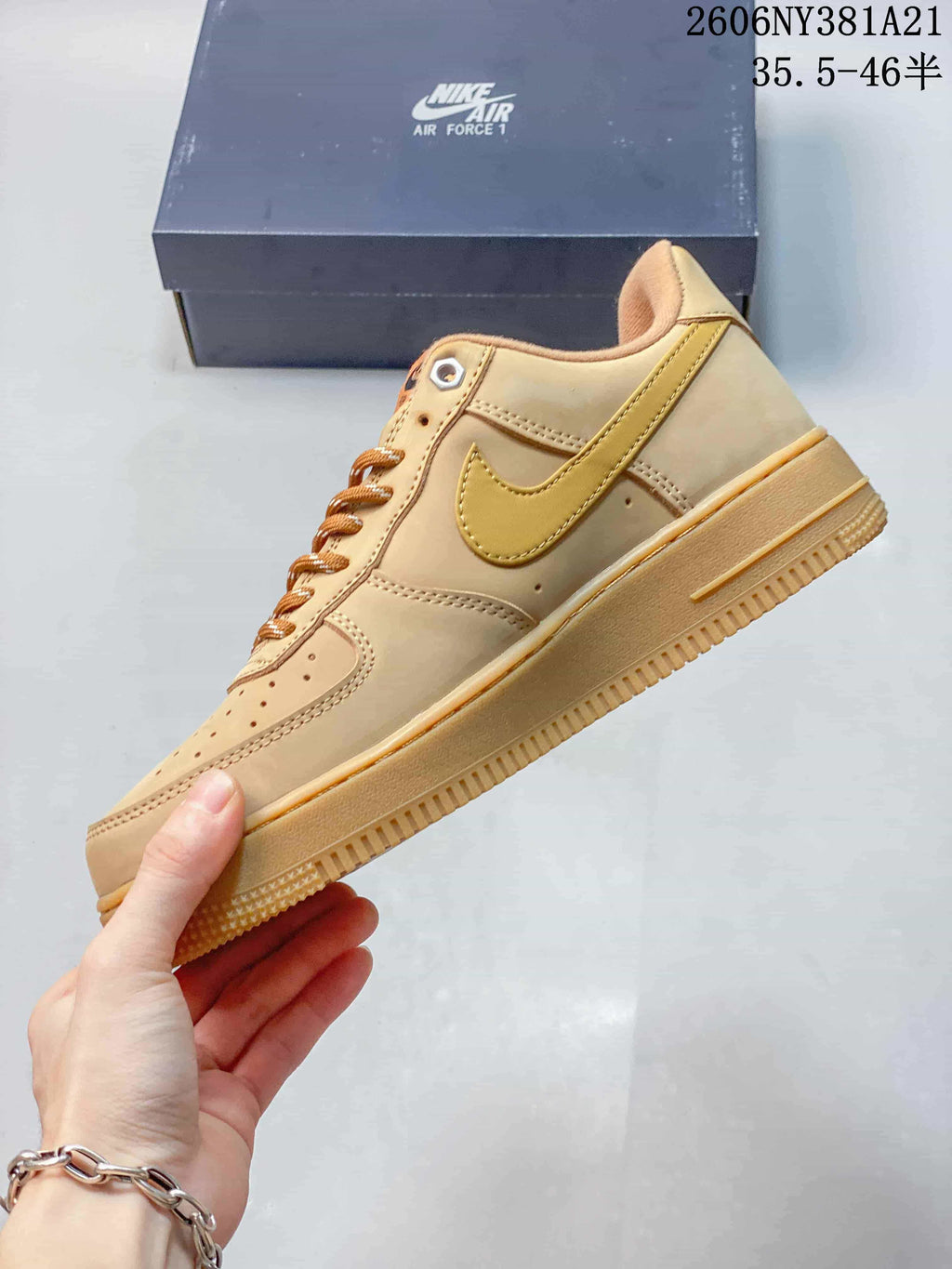 Side view of the tan low-top sneaker with a golden-yellow Swoosh and textured sole