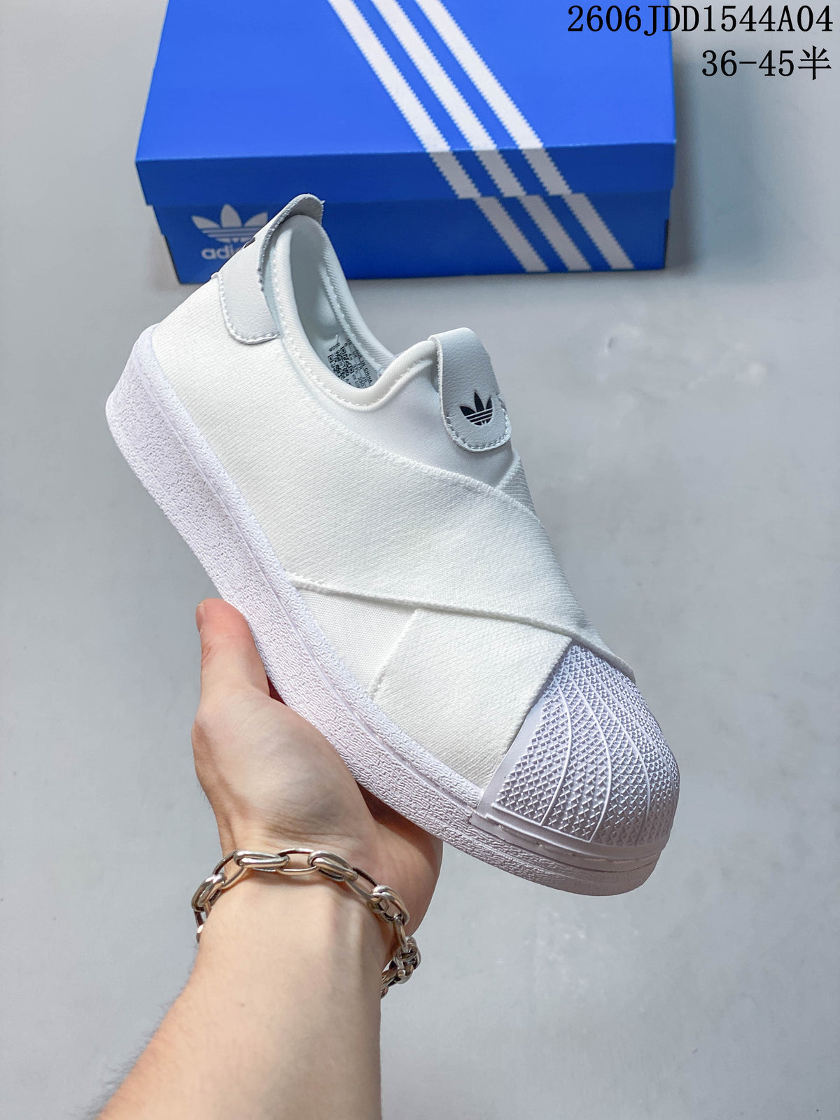 Angled view of the white slip-on sneaker with elastic bands and a textured shell toe.