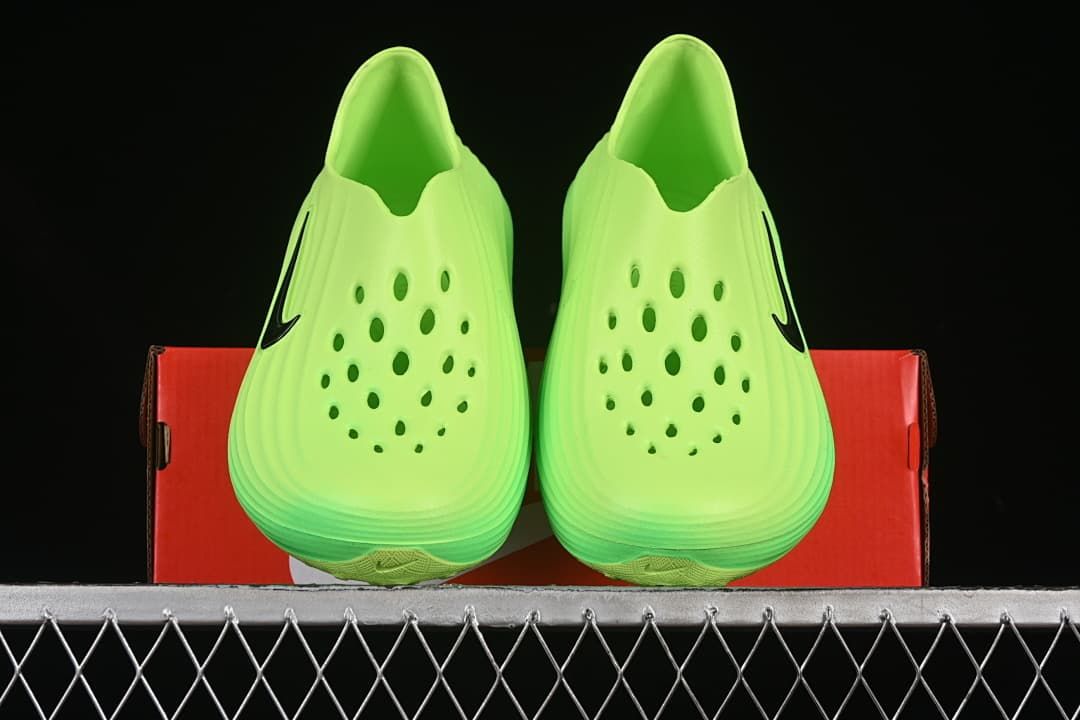 Pair of green clogs shown from the front with perforated uppers.