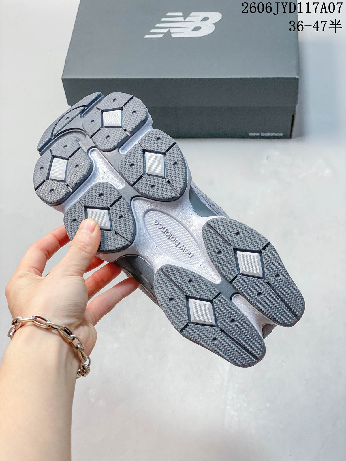 Underside of a grey New Balance 9060 sneaker showing segmented outsole tread