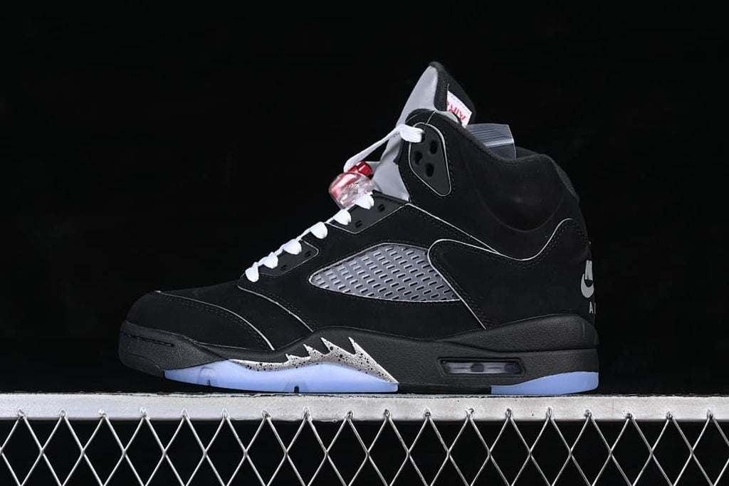 Side view of a black Air Jordan 5 high-top sneaker with white laces, gray panels, and icy blue outsole accents