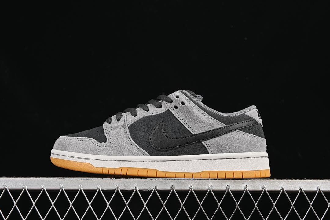 Side view of the grey and black low-top sneaker against a dark background