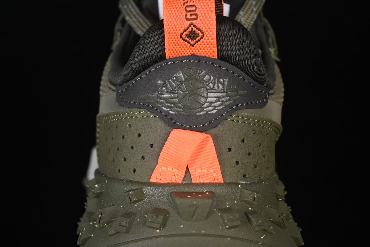 Close-up of the heel panel, embossed Jordan Wings mark, and orange pull tab.
