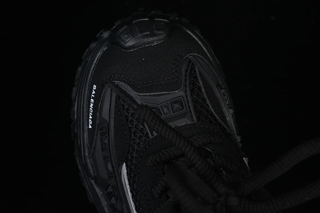 Top view of the black sneaker showing the toe, laces, and branding.
