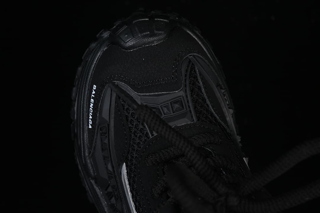 Top view of the black sneaker showing the toe, laces, and branding.