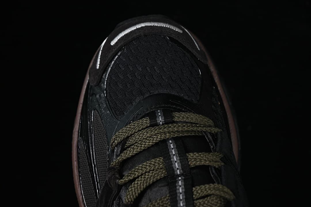 Top-down close-up of the black toe and olive-toned laces.