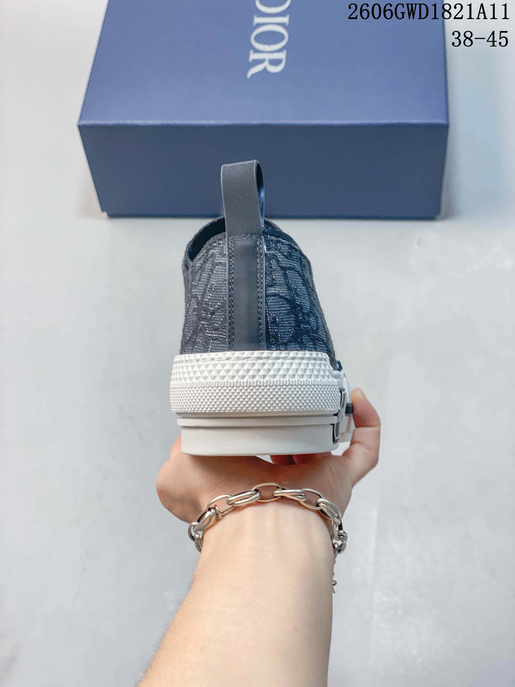 Rear view of a gray patterned sneaker with a heel pull tab and white sole