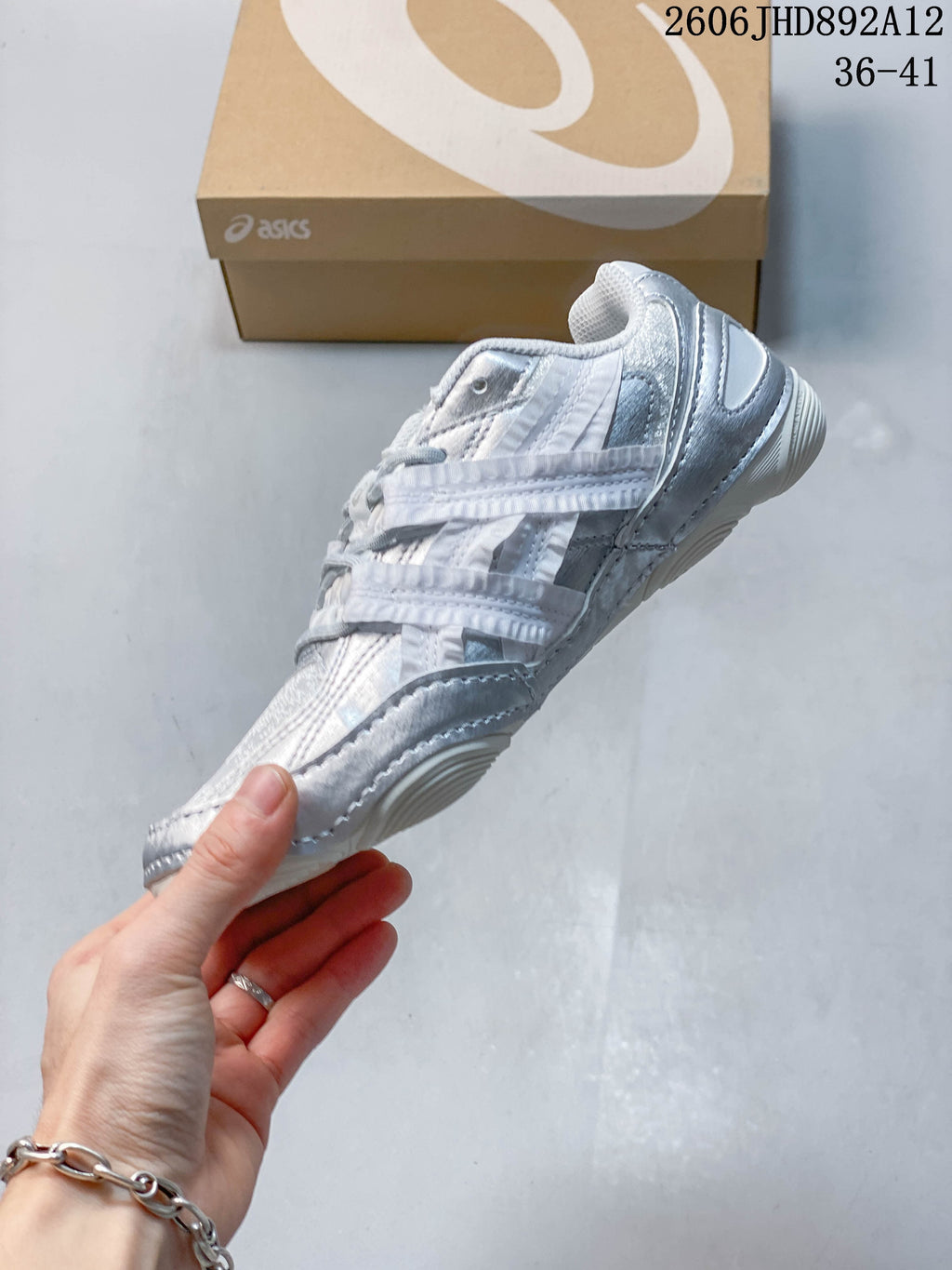 Side view of the silver and light gray low-top sneaker