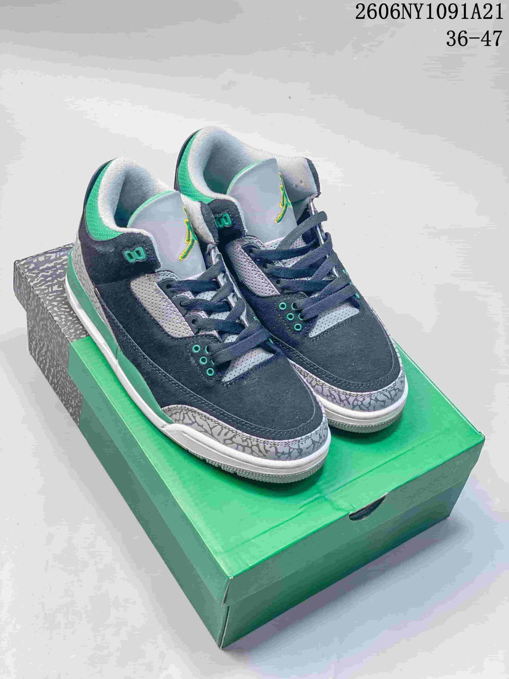 Pair of navy, grey, and green Air Jordan 3 mid-top sneakers shown from the front three-quarter view