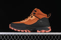 Side profile of an orange and black Timberland mid hiking boot