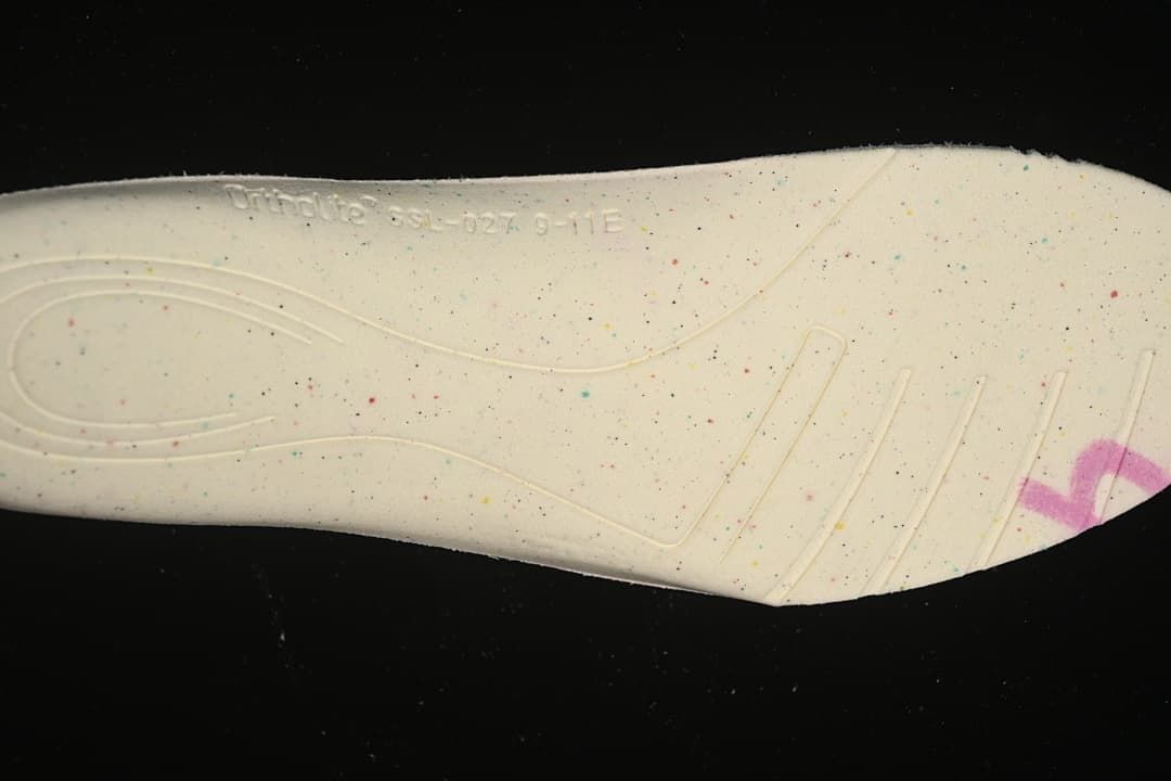Close-up of the light-colored shoe outsole with small colored speckles.