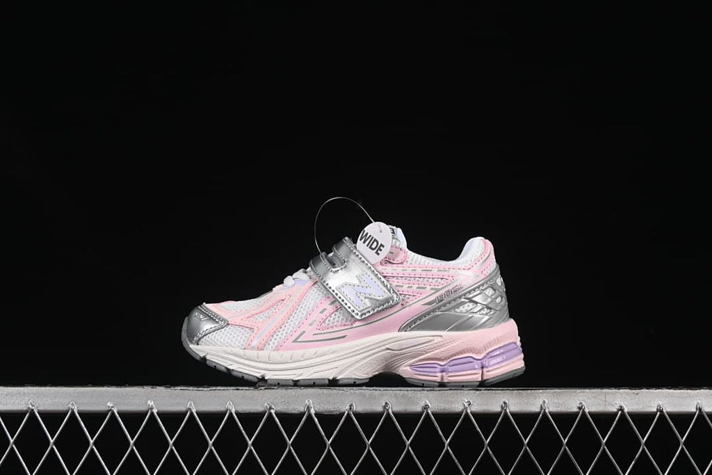 Side view of the pink, silver, and white kids’ sneaker with a visible “WIDE” tag.