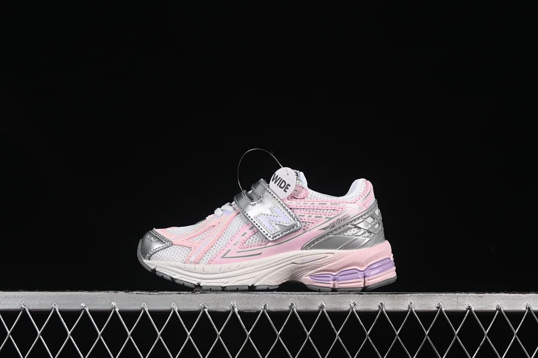 Side view of the pink, silver, and white kids’ sneaker with a visible “WIDE” tag.