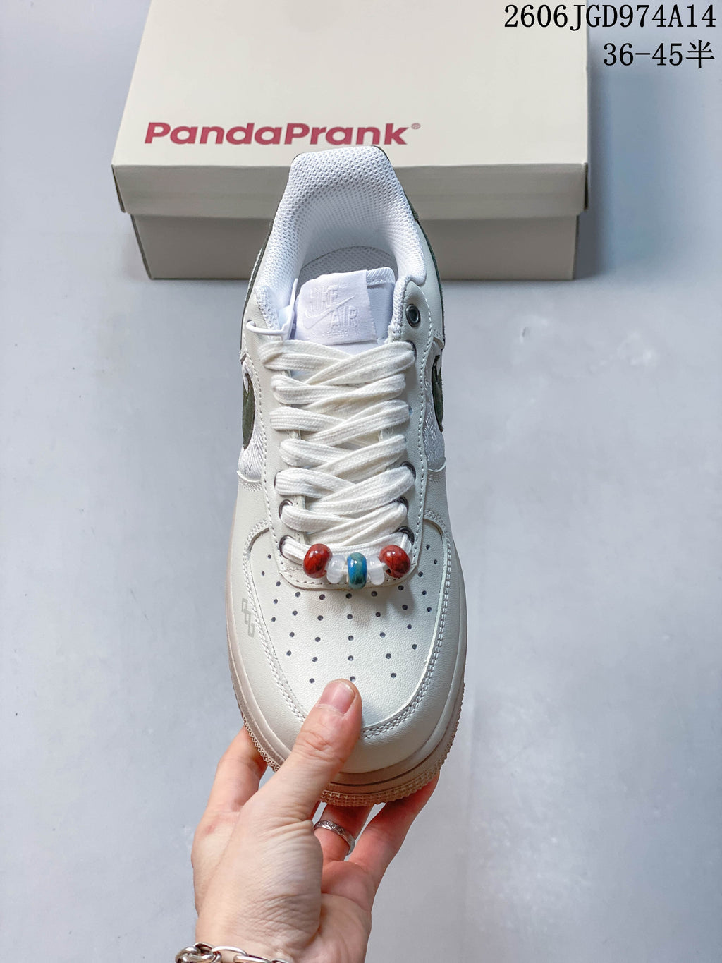 Front view showing perforated toe, white laces, and multicolor lace beads
