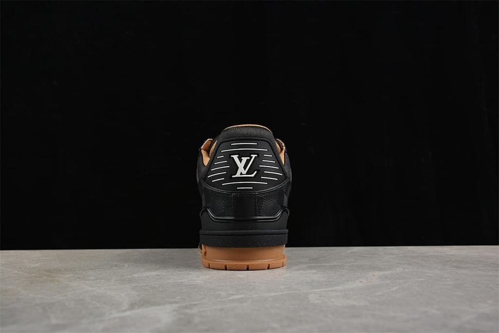 Rear view of a black sneaker with logo detailing and a tan-colored outsole