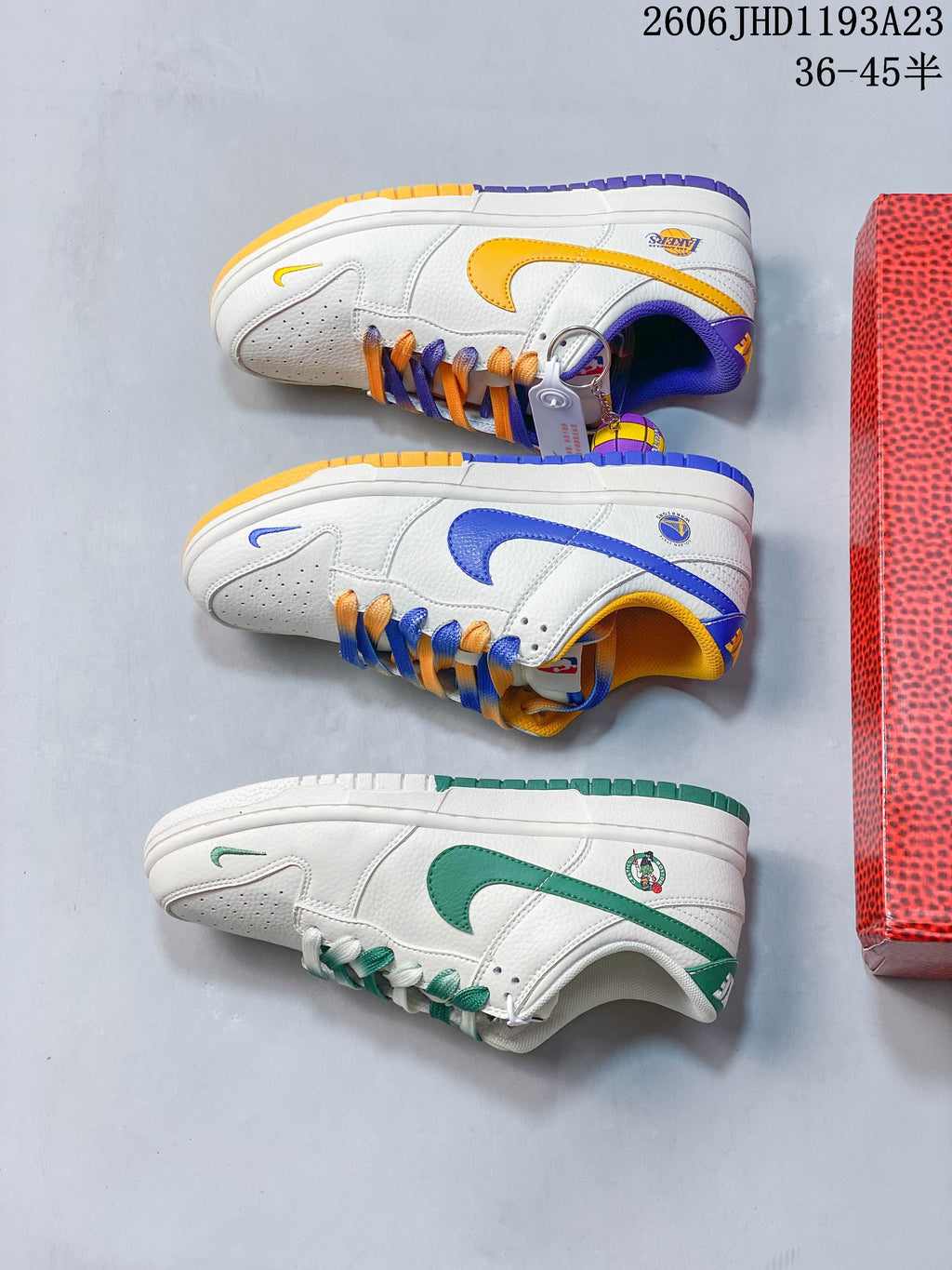 Three white low-top sneakers displayed in blue and yellow, purple and gold, and green color combinations.