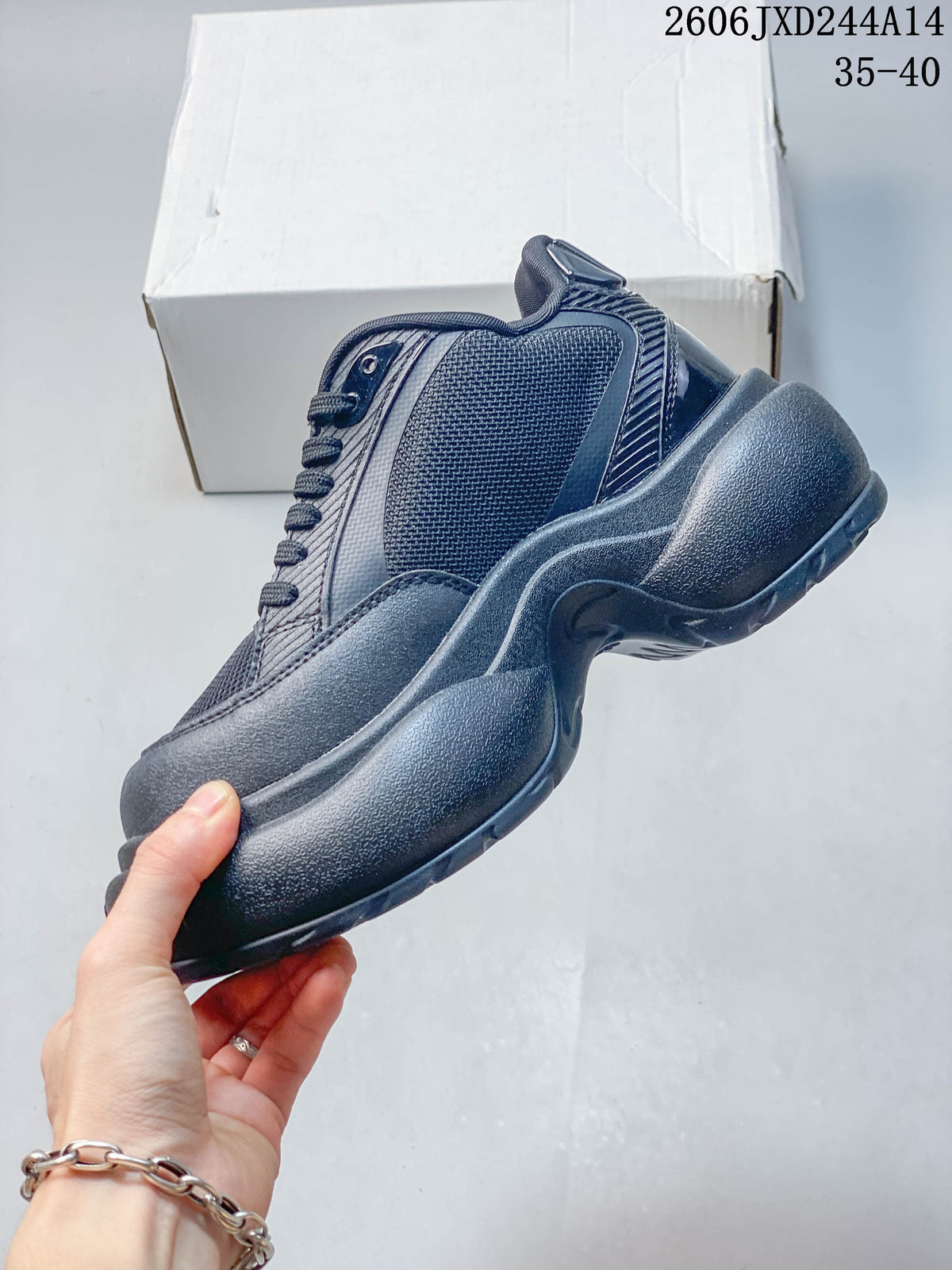 Side profile of a charcoal SMFK sneaker showing mesh-look panels and a chunky sole.