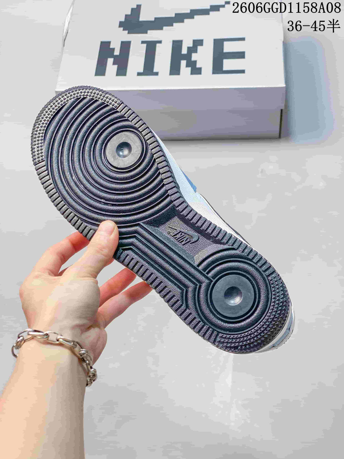 Close-up of the sneaker's patterned outsole beside a shoebox